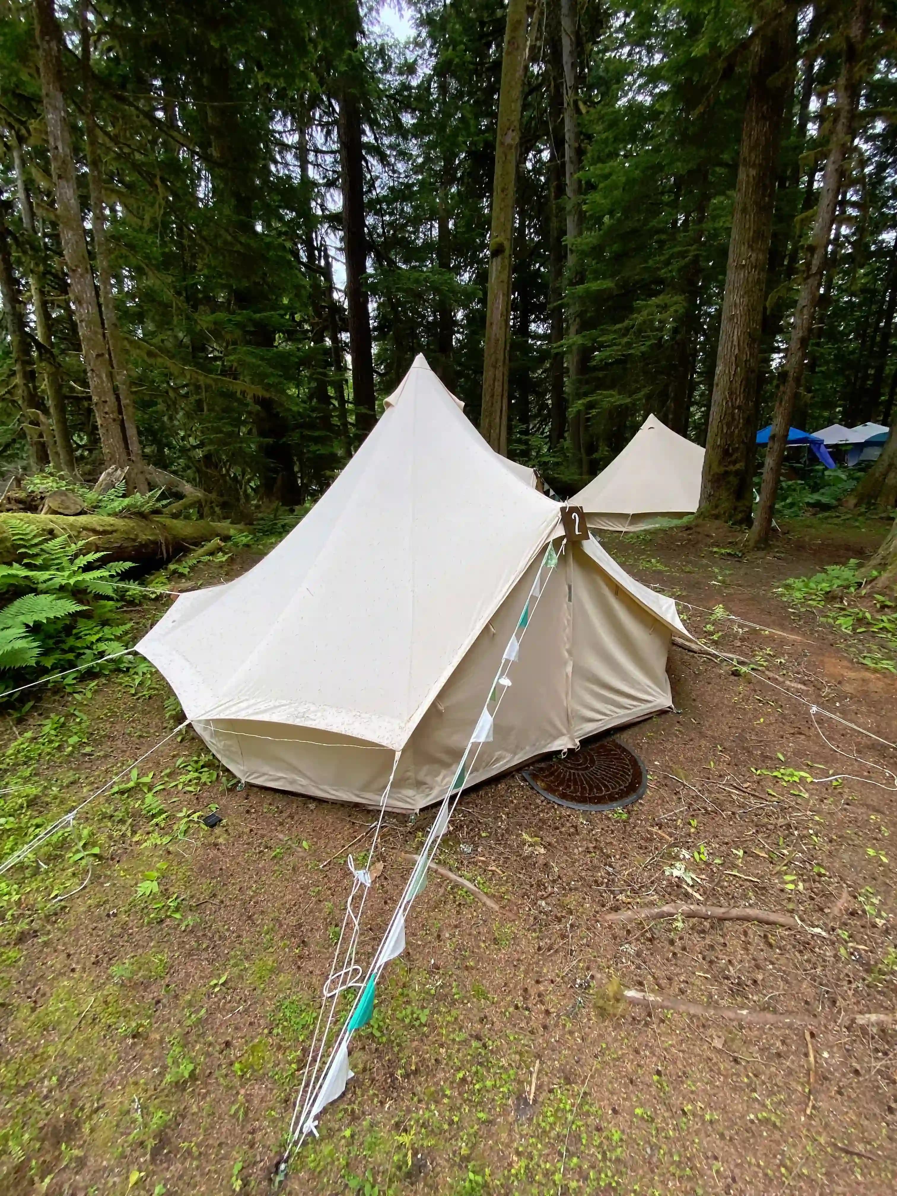 Interior of a tent with two beds and striped bedding.
